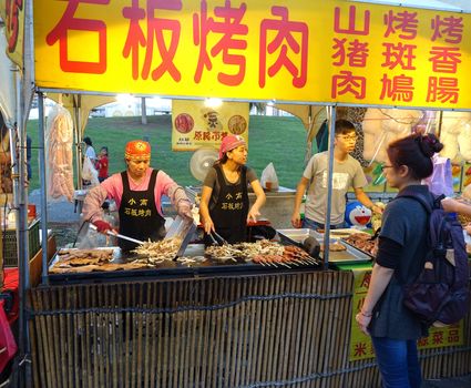 KAOHSIUNG, TAIWAN -- FEBRUARY 13, 2016: A stall sells indigenous foods cooked on an iron griddle during the 2016 Lantern Festival.

