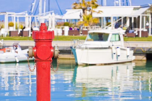 Red fire hydrant in a harbor - concept image with copy space