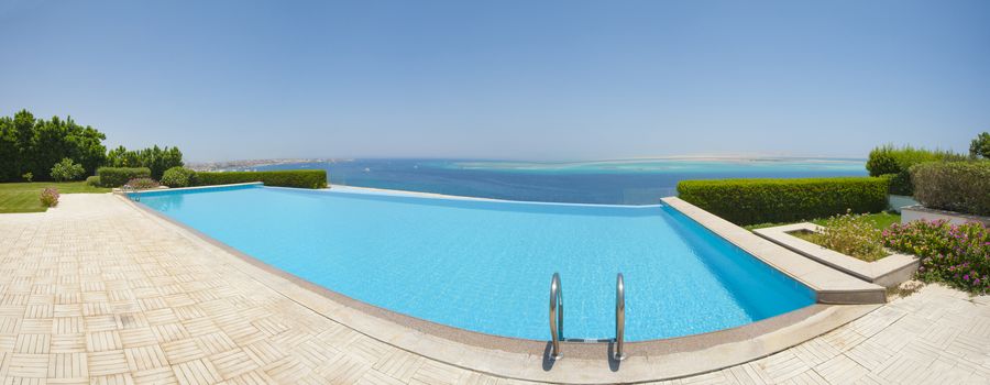 Panoramic view from a luxury infinity swimming pool with tropical sea outlook