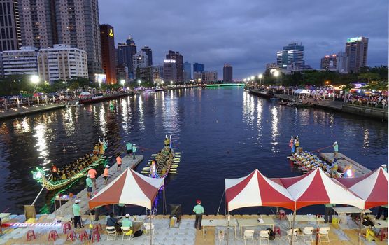 KAOHSIUNG, TAIWAN -- MAY 30, 2017: Three unidentified teams compete in the Dragon Boat Races on the Love River in Taiwan in the evening.