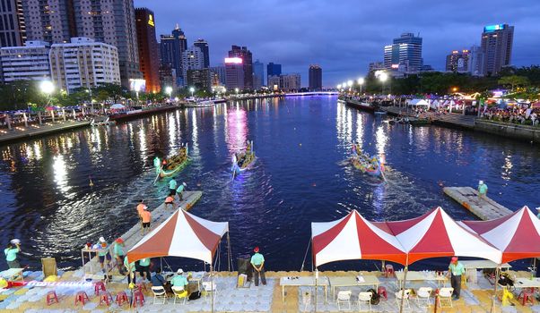 KAOHSIUNG, TAIWAN -- MAY 30, 2017: Three unidentified teams compete in the Dragon Boat Races on the Love River in Taiwan in the evening.