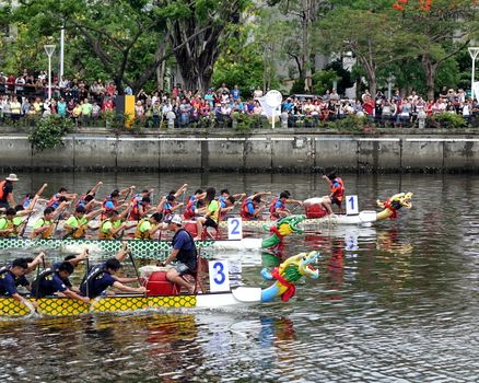KAOHSIUNG, TAIWAN -- MAY 30, 2017: Three unidentified teams compete in the Dragon Boat Races on the Love River in Taiwan.