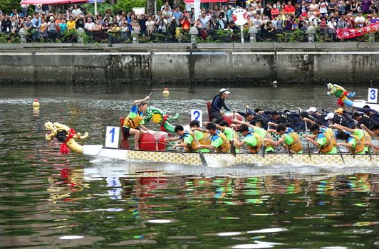KAOHSIUNG, TAIWAN -- MAY 30, 2017: Three unidentified teams compete in the Dragon Boat Races on the Love River in Taiwan.
