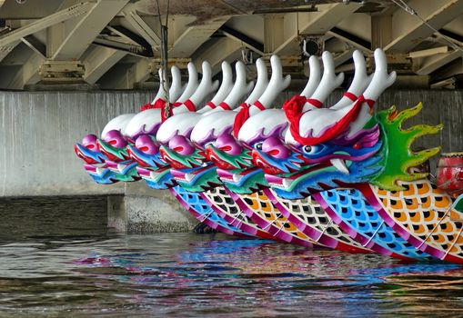 KAOHSIUNG, TAIWAN -- JUNE 10, 2018: A row of dragon boats with the traditional figureheads is being prepared for the upcoming Dragon Boat Festival.

