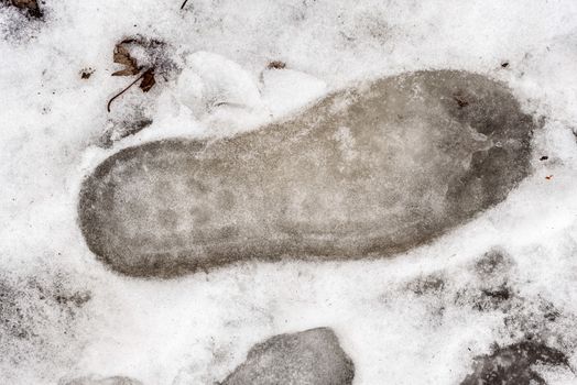 Footprint in the cold snow in winter