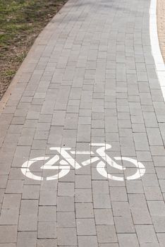 White bike path sign painted on a lane in the Natalka park of Kiev, Ukraine