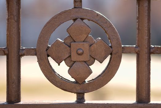 Closeup detail of a metallic fence decoration with cross and circle around