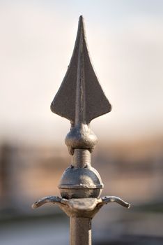 Closeup detail of a metallic arrow on a fence