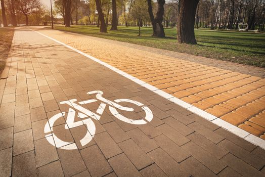 White bike path sign painted on a lane in the Natalka park of Kiev, Ukraine