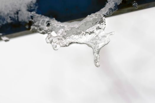 Water stalactites dropping during the cold and gray winter