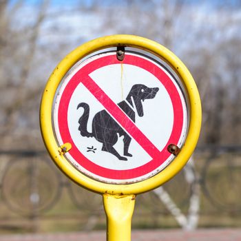 A sign in a park for no poop with the icon of a dog pooping.