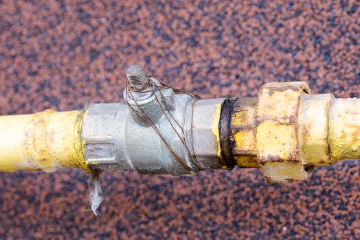 A yellow gas tube, with a tap, outside of a house to canalize the soft energy at home.