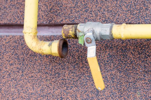 A broken yellow gas tube, with a tap, outside of a house to canalize the soft energy at home.