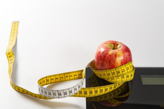 Diet plan, menu or program, tape measure, diet food of fresh fruits on white background, weight loss and detox concept, top view. weight loss concept. Apple and measuring tape. Diet