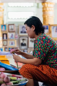 Thai buddhism people in buddhist pray for benefaction worship by incense and garland to Buddha or spirit-house at shrine or Thai temple (Wat Thai)