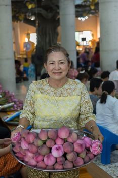 Thai buddhism people in buddhist pray for benefaction worship by incense and garland to Buddha or spirit-house at shrine or Thai temple (Wat Thai)