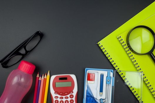 Various school supplies. studying, education and back to school concept. Black background and selective focus.