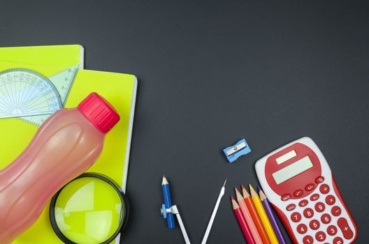 Various school supplies. studying, education and back to school concept. Black background and selective focus.