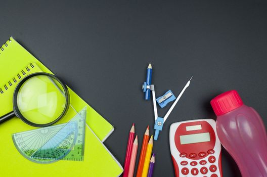 Various school supplies. studying, education and back to school concept. Black background and selective focus.