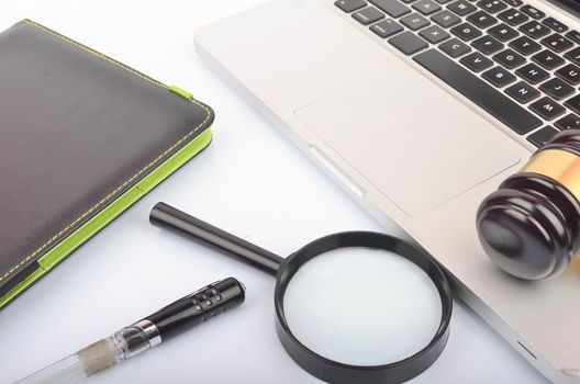 Cyber crime concept. Judge hammer or gavel with laptop on white background. Selective focus.