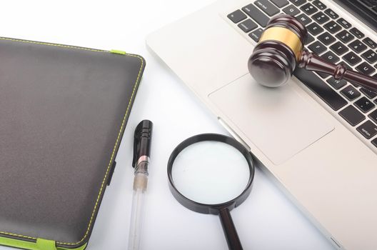 Cyber crime concept. Judge hammer or gavel with laptop on white background. Selective focus.