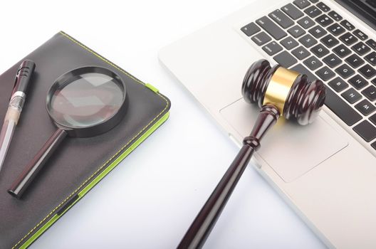 Cyber crime concept. Judge hammer or gavel with laptop on white background. Selective focus.