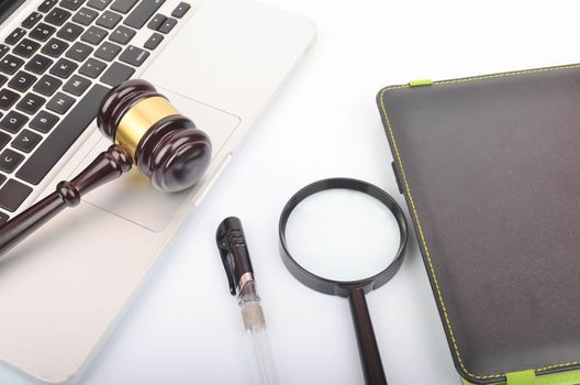 Cyber crime concept. Judge hammer or gavel with laptop on white background. Selective focus.