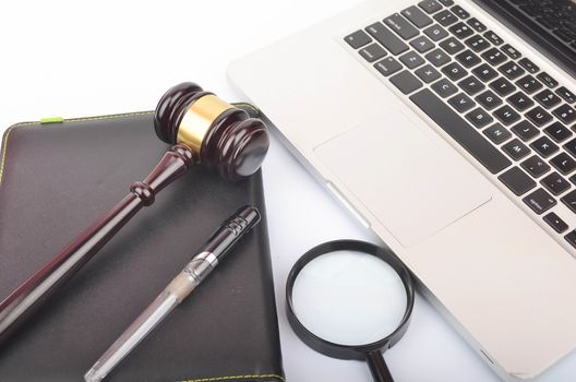 Cyber crime concept. Judge hammer or gavel with laptop on white background. Selective focus.