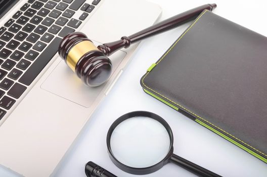 Cyber crime concept. Judge hammer or gavel with laptop on white background. Selective focus.