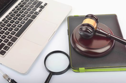 Cyber crime concept. Judge hammer or gavel with laptop on white background. Selective focus.