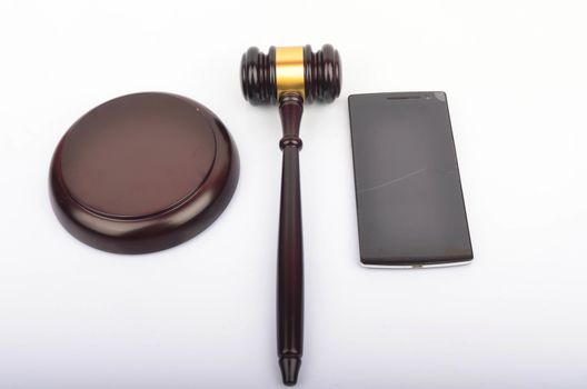 Judge hammer or gavel with smartphone on white background. Justice and law concept. Selective focus.