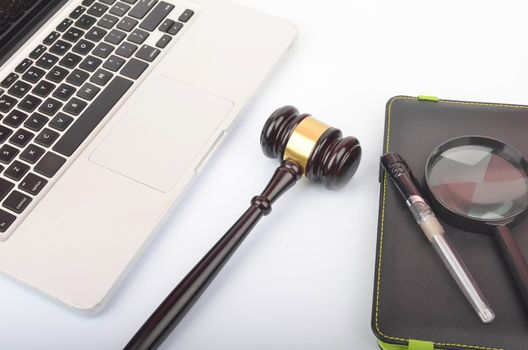 Cyber crime concept. Judge hammer or gavel with laptop on white background. Selective focus.