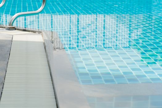 Close up of vortex Beside edge swimming pool cleaning machine and Maintenance and Cleaning Stick with the pool stairs and clear water background. sport and healthy concept.