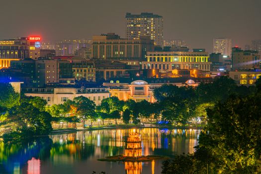 OLD QUARTER, HANOI/VIETNAM - JULY 16: Night view of The Huc bridge and Ngoc Son temple on 07 16 2019 in Lake of the Returned Sword, Hoan Kiem Lake, Turtle Tower. City view of background.