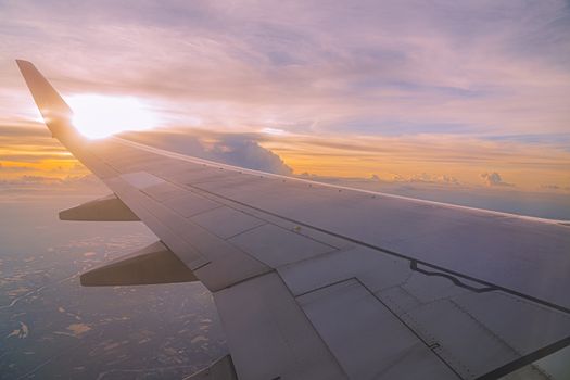 Beautiful sunset, sky on the top view, airplane flying view from inside window and cloud, sun down background aircraft of Traveling.