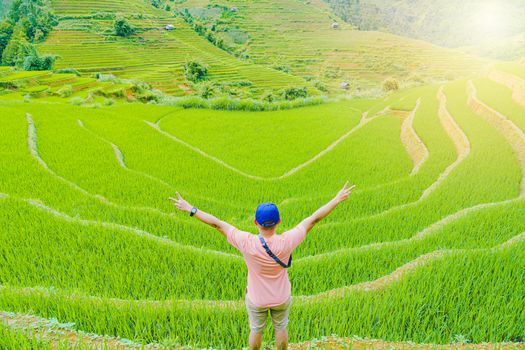 The only man standing with his back beautiful terraced rice paddy field and mountain landscape in Mu Cang Chai and SAPA VIETNAM Sunlight and flare background concept.