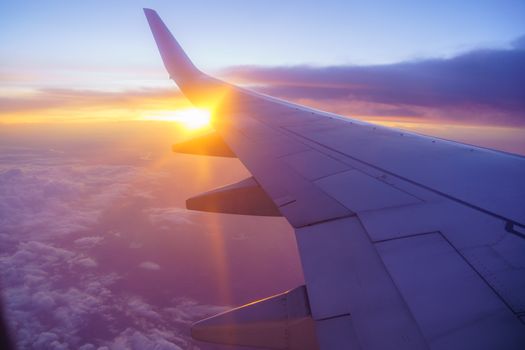 Beautiful sunset, sky on the top view, airplane flying view from inside window and cloud, sun down background aircraft of Traveling.