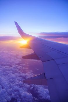 Beautiful sunset, sky on the top view, airplane flying view from inside window and cloud, sun down background aircraft of Traveling.