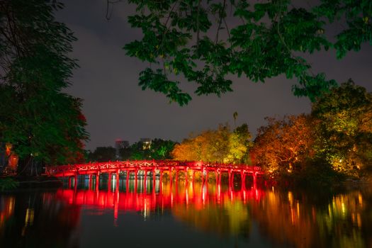 Night view of The Huc bridge and Ngoc Son temple. Lake of the Returned Sword, Old red wooden bridge, Hoan Kiem Lake. Landmark in city vietnam. vietnamese