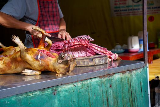 Man Dissected, pay Dog meat Dead body selling a grilled for barbecue Street food of Vietnam. Food is difficult.