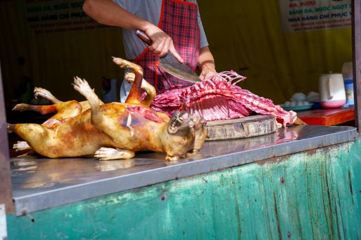 Man Dissected, pay Dog meat Dead body selling a grilled for barbecue Street food of Vietnam. Food is difficult.