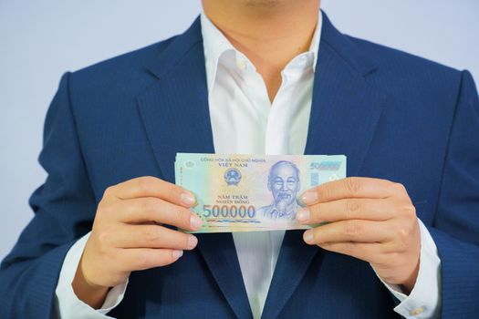 Money in Vietnam hold on hand business man wearing a blue suit (Socialist Republic Of Vietnam), Dong, VND, Pay, exchange money vietnamese on white background.