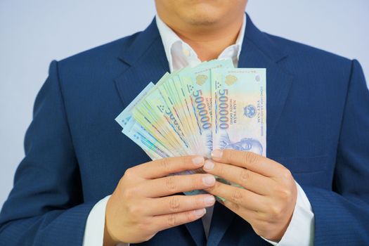 Money in Vietnam hold on hand business man wearing a blue suit (Socialist Republic Of Vietnam), Dong, VND, Pay, exchange money vietnamese on white background.