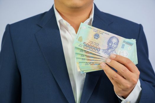 Money in Vietnam hold on hand business man wearing a blue suit (Socialist Republic Of Vietnam), Dong, VND, Pay, exchange money vietnamese on white background.