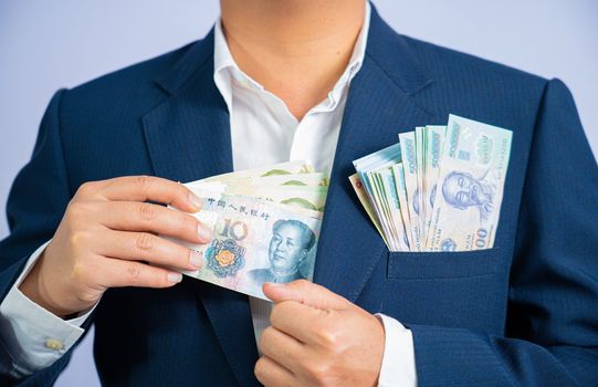 Money in China hold on hand business man and Money in Vietnam Dong, VND, wearing a blue suit  CNY, Pay, exchange money People’s Republic of China (PRC) on white background.