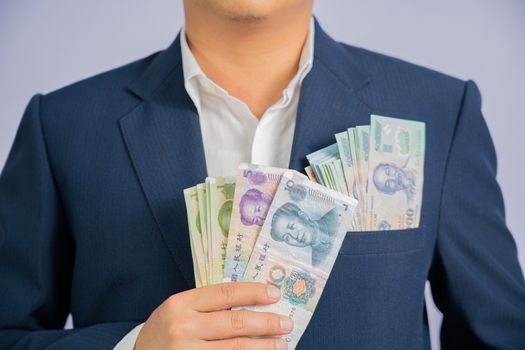 Money in China hold on hand business man and Money in Vietnam Dong, VND, wearing a blue suit  CNY, Pay, exchange money People’s Republic of China (PRC) on white background.