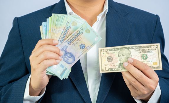 Money in us dollar hold on hand business man and Money in Vietnam (VND) hold on hand business man wearing a blue suit wearing a blue suit and us dollar USD, Pay, exchange money vietnamese on white background.