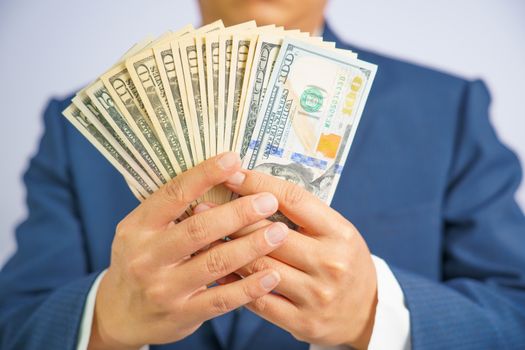 Money in USA hold on hand business man wearing a blue suit USD, Pay, exchange money.