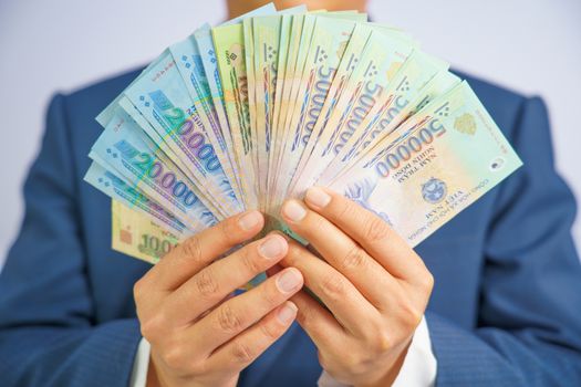 Money in Vietnam hold on hand business man wearing a blue suit (Socialist Republic Of Vietnam), Dong, VND, Pay, exchange money vietnamese on white background.