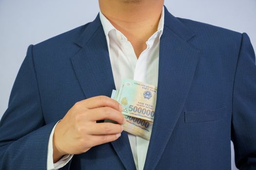 Money in Vietnam hold on hand business man wearing a blue suit (Socialist Republic Of Vietnam), Dong, VND, Pay, exchange money vietnamese on white background.